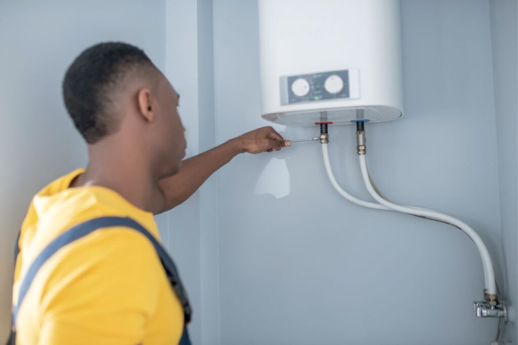 man repairing a tankless water heater